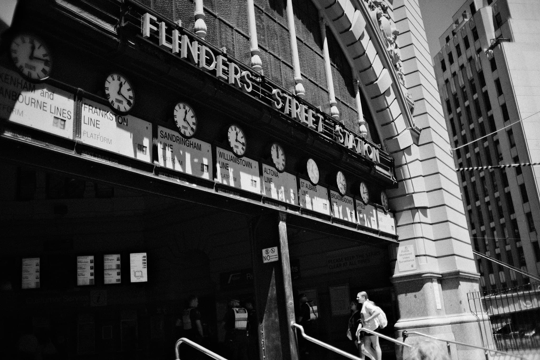 Flinders Street Station clocks with lone figure on stairs