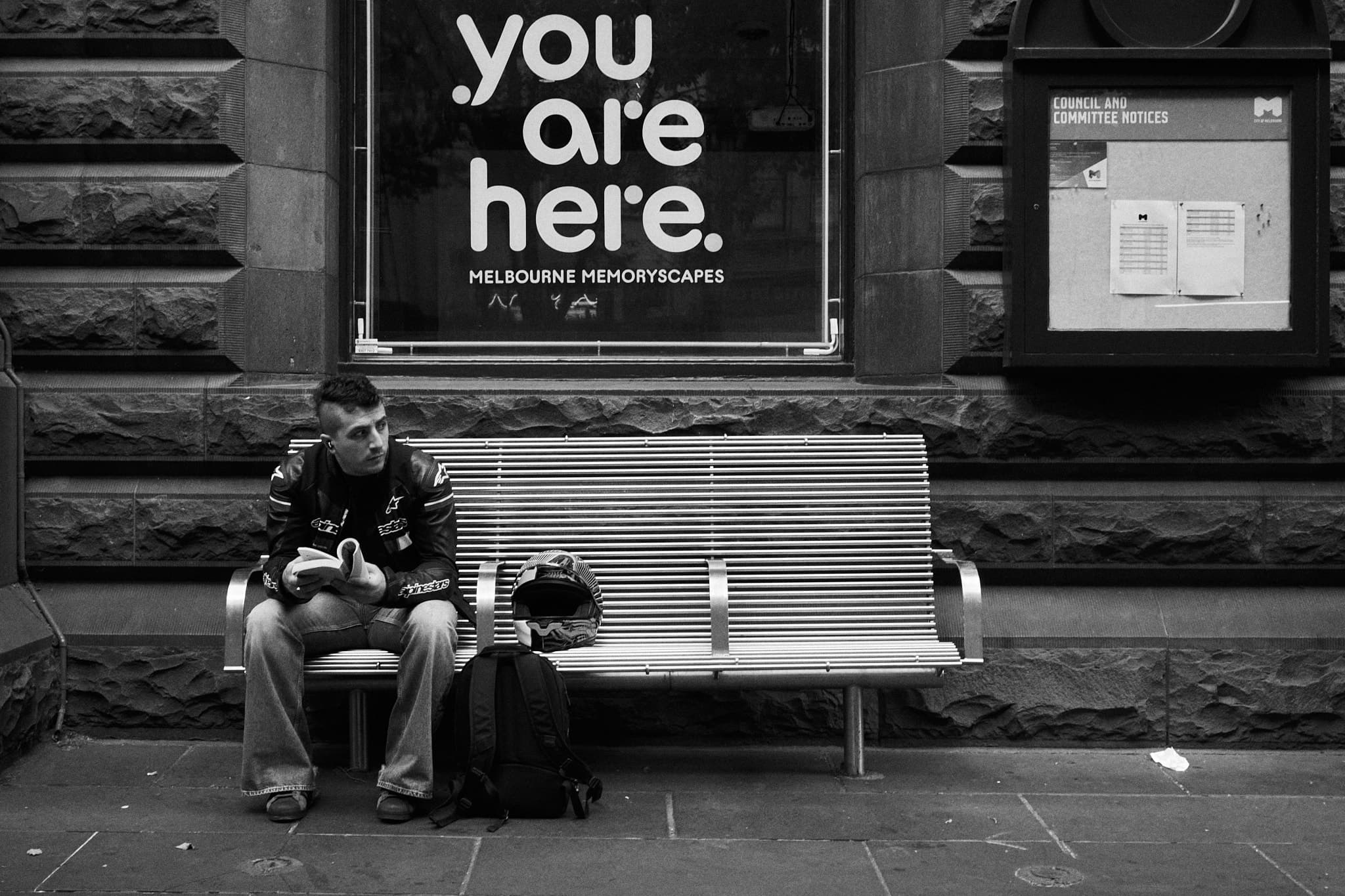 You Are Here sign with man alone on bench below